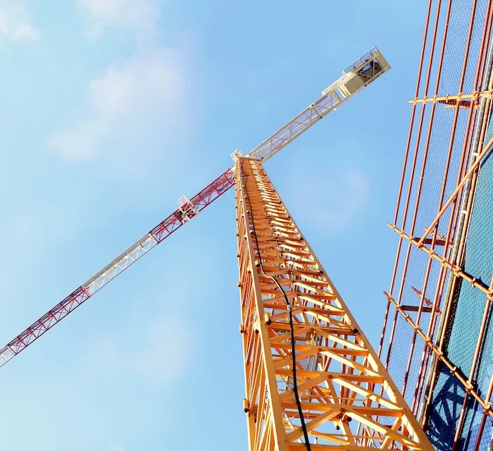 Tower crane and high-rise scaffolding system coordinated by Ontario Scaffolding on a large commercial construction site.
