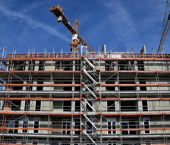 Multi-story residential building supported by exterior scaffolding installed by Ontario Scaffolding during construction.
