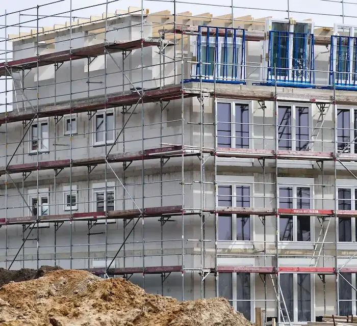 Multi-story residential building under construction with full exterior scaffold system by Ontario Scaffolding