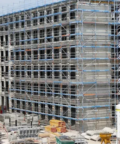 Large commercial construction site with grid scaffolding system surrounding multi-floor structure by Ontario Scaffolding