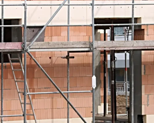 Construction workers operating on reinforced scaffolding platforms installed by Ontario Scaffolding at an active job site.